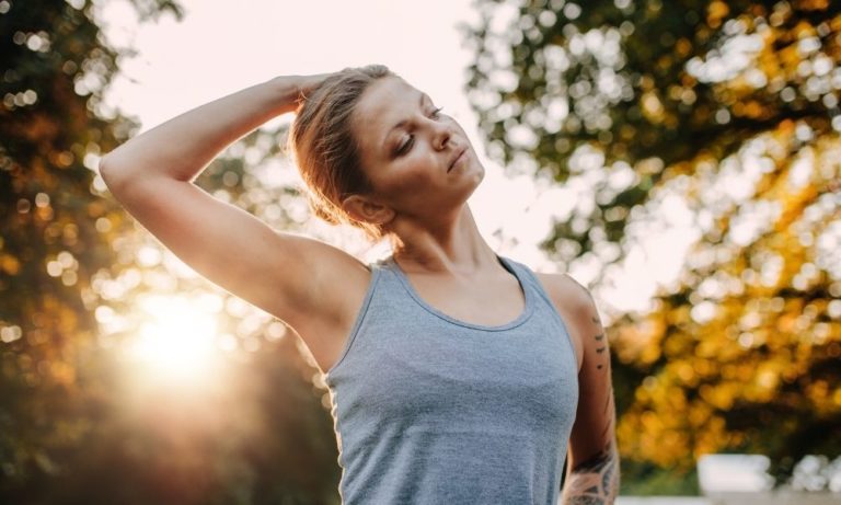 Athletic woman stretching neck before exercising